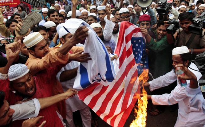Bangladeshi Muslims burn flags of the US and Israel during a protest in Dhaka on Friday. Photo: AP