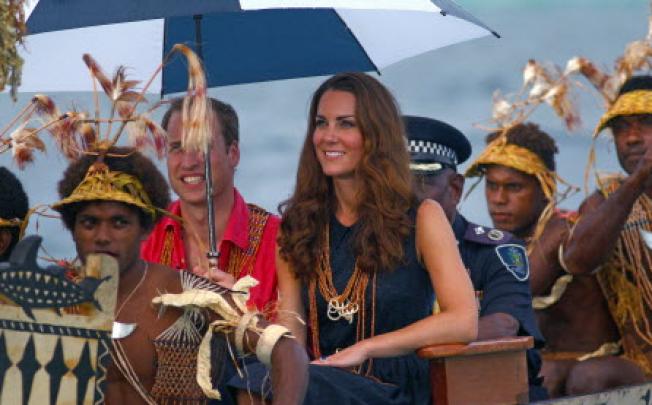 Britain's Prince William (centre left) and his wife Catherine (centre), the Duchess of Cambridge, arrive in Tavanipupu on a traditional war canoe on Monday. Photo: AFP