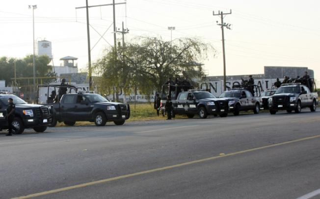 A group of Mexican federal police stand in front of the prison in Piedras Negras on Monday. Photo: AP
