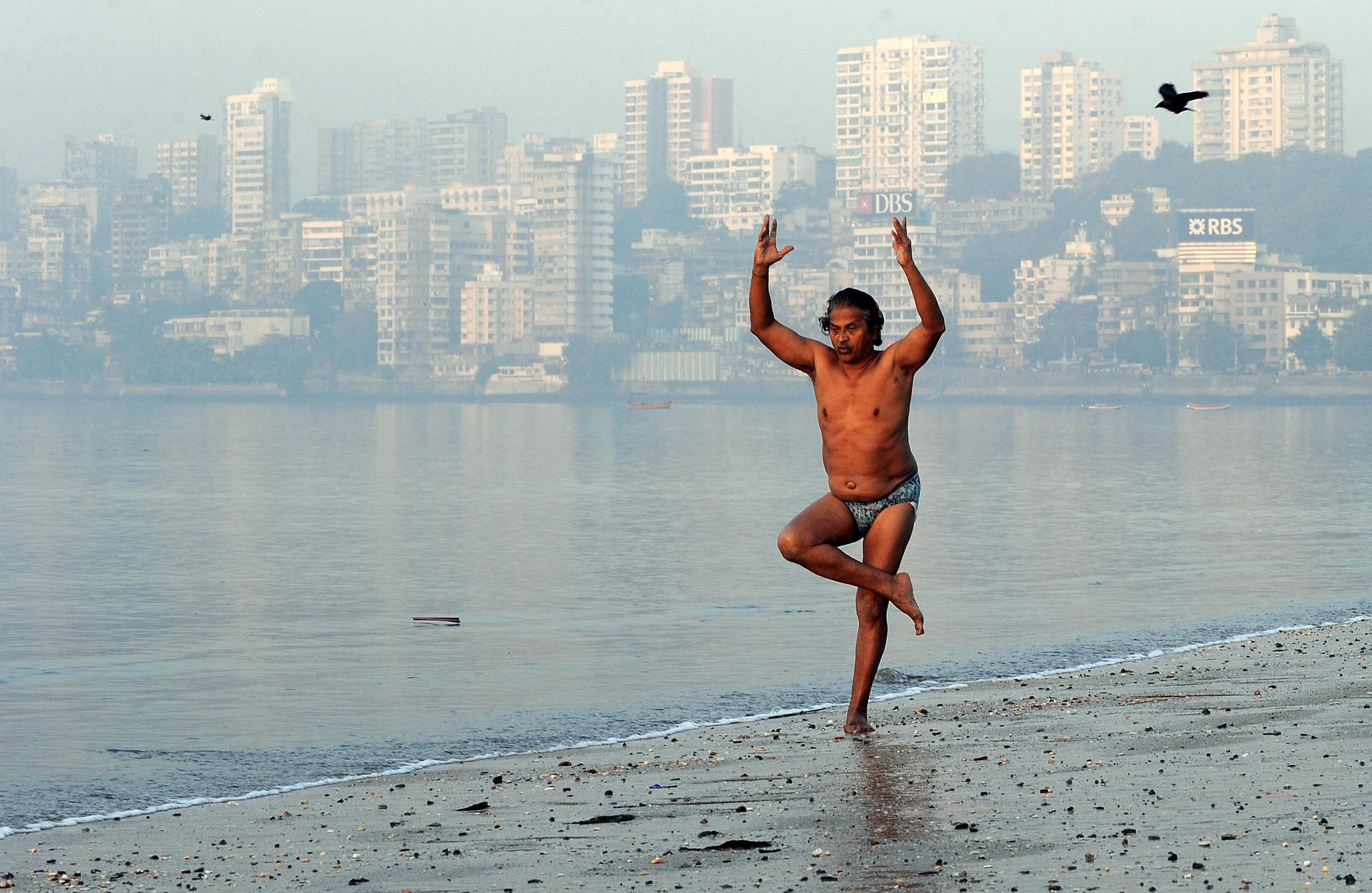 A yoga practitioner goes through his daily routine on a Mumbai beach. Photo: AFP