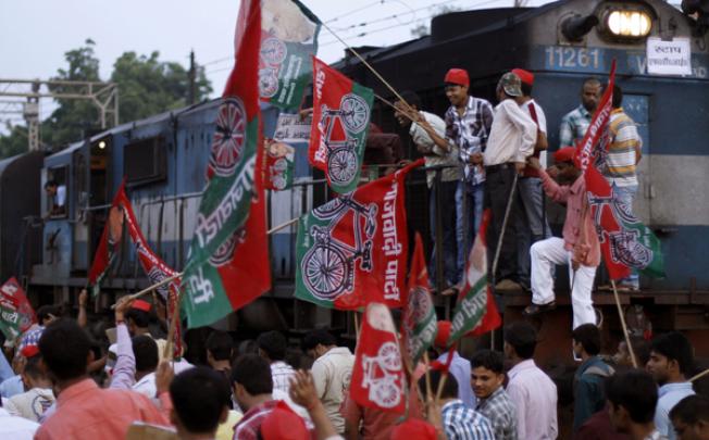 Samajwadi Party activists hold party flags and block a railway track during a protest in Allahabad, India, on Thursday. Photo: AP