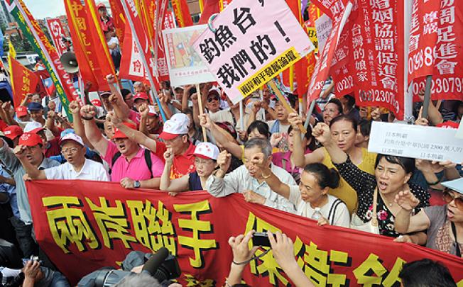 Protesters from right-wing parties and civil groups call for a boycott of Japanese goods as they march against Japan's claim of sovereignty of the Diaoyu Islands on Sunday. Photo: AFP