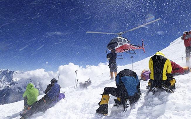 A helicopter lifts avalanche survivors to safety on Mount Manaslu on Sunday. Photo: AP