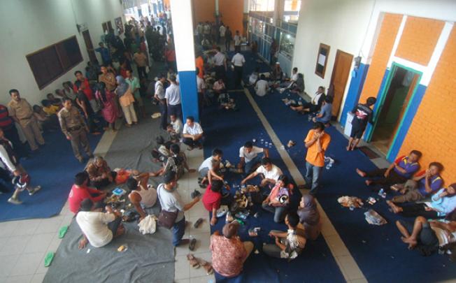 Victims of a ship that collided with a cargo tanker rest at Bakauhuni port in Bakauhuni, Lampung on Wednesday. Photo: AFP