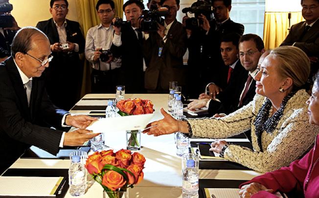 US Secretary of State Hillary Clinton (right) is handed an envelope from Myanmar's President Thein Sein as they meet in New York on Wednesday. Photo: AP