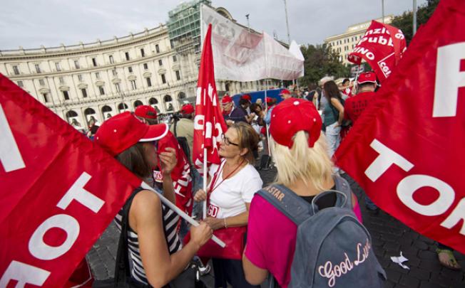 Workers gather on the Piazza della Repubblica in Rome to attend a protest march during a general strike on Friday. Photo: EPA