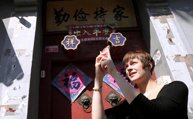 Emily Schreck, known as Beijingemily, takes a photo of a Beijing hutong to share with Chinese and English Instagram fans. Photo: Simon Song