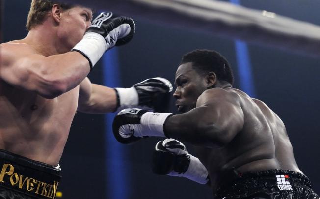 Russia's heavyweight boxer Alexander Povetkin (left) exchanges punches with Hasim Rahman on Saturday. Photo: AFP