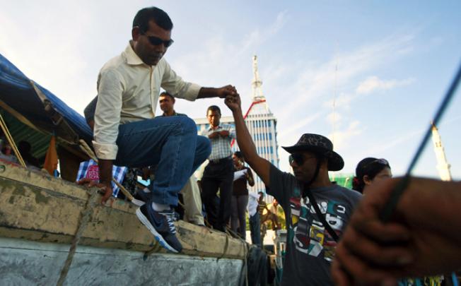 Maldives' ex-president Mohamed Nasheed gets into a fishing vessel to depart for his campaign visit in Male on Monday. Photo: AP