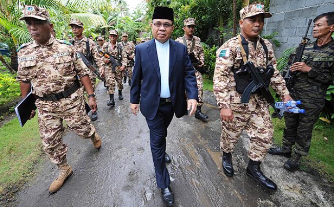 Moro Islamic Liberation Front chairman Murad Ebrahim is escorted by his troops to their base camp in Darapan, Sultan Kudarat province, Philippines. Photo: AFP