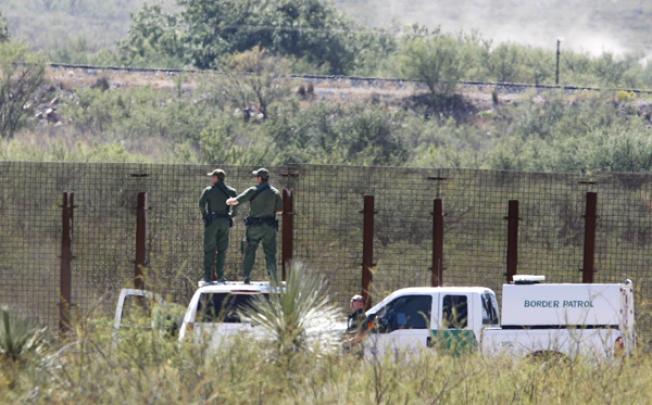 US Border Patrol agents stand on top of their vehicles and look into Mexico west of Douglas, Arizona, on Tuesday. Photo: AP