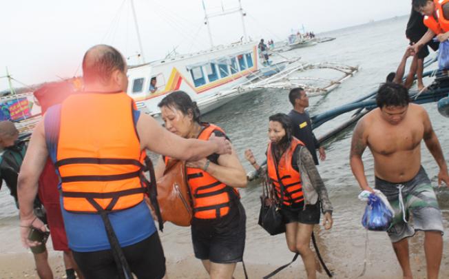 Philippine rescuers save tourists from a boat capsized on the rough sea off the resort island of Borocay on Wednesday. Photo: Xinhua