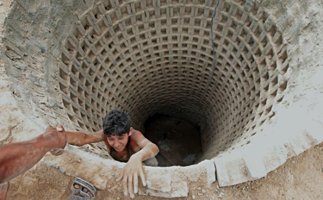 A smuggler ascends from a tunnel along the Gaza-Egypt border. The tunnels are a lifeline for supplies of food, clothes, building materials and fuel into the Palestinian territory subjected to an Israeli blockade since 2006. Photo: AFP
