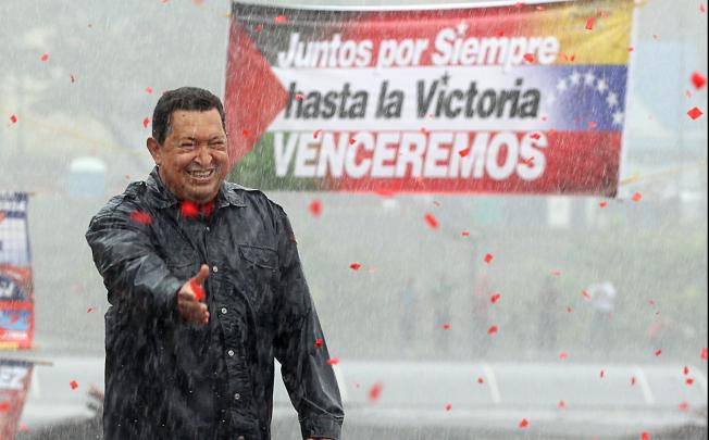 Venezuelan President Hugo Chavez, greets supporters under a heavy rain during his closing campaign rally on Avenida Bolivar, in Caracas, on Thursday. Photo: AP