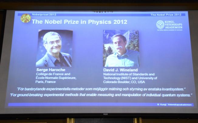 Pictures of Serge Haroche and David Wineland are projected on a screen on Tuesday at the Royal Swedish Academy of Science in Stockholm. Photo: AFP