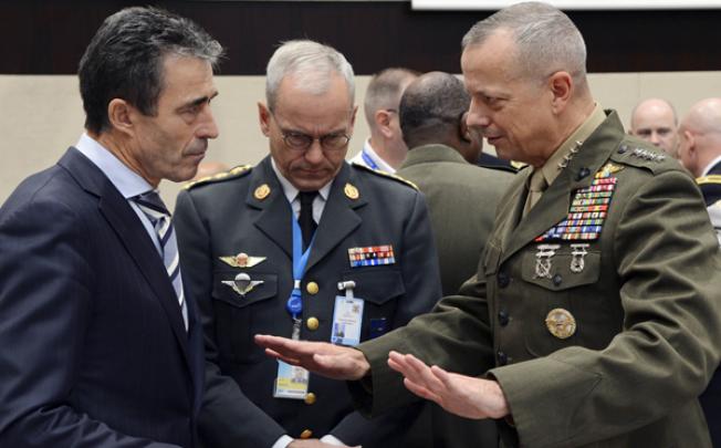 Nato Secretary General Anders Fogh Rasmussen (left) listens to ISAF Commander US General John Allen prior to the start of a Nato Defence Ministers meeting in Brussels on Wednesday. Photo: AFP