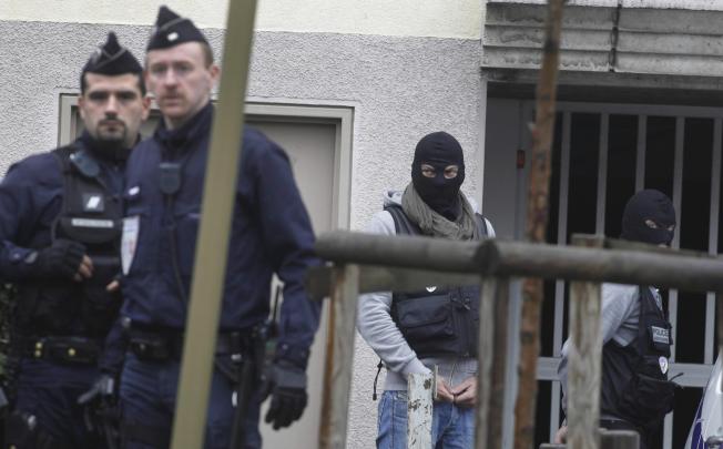 Police at the Paris estate where the cache of bomb-making materials and weapons were found. Photo: AP