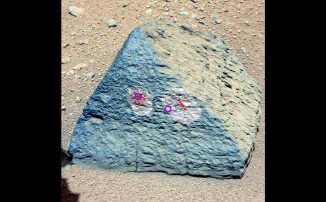 A handout photo provided by NASA on 11 October 2012 and taken by the Curiosity rover's right Mast Camera (Mastcam-100) on 22 September 2012, shows a rock known as 'Jake Matijevic' with the red dots showing where the Chemistry and Camera (ChemCam) instrument zapped it with its laser. Photo: EPA