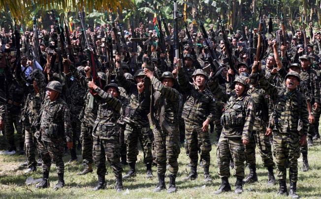 As the pact is signed in Manila, Moro Islamic Liberation Front rebels in Muslim Mindanao raise their firearms in celebration. Photo: Reuters