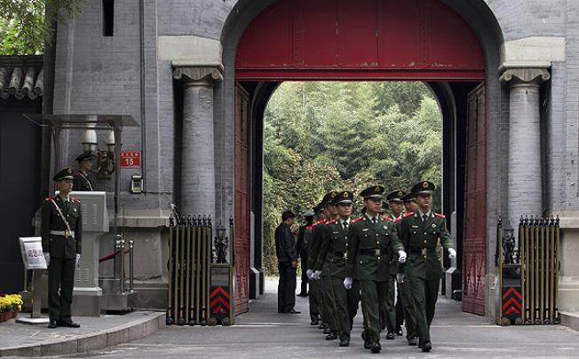 Paramilitary policemen march at the home of the former Cambodian king in Beijing. Photo: AP