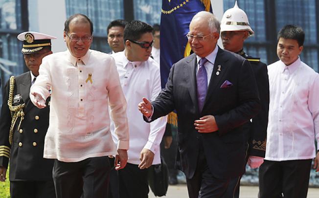 Philippine President Benigno Aquino welcomes Malaysian Prime Minister Najib Razak, who arrived in Manila to witness the landmark signing. Photo: AP