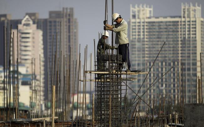 Building workers erect scaffolding in Wuhan, which is part of an emerging urban cluster. Photo: Reuters