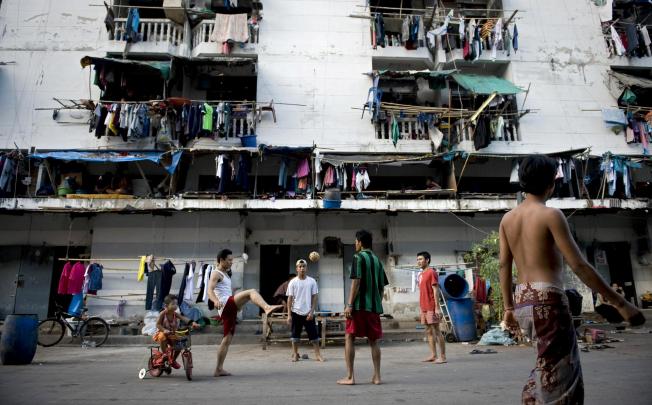 Myanmese migrant workers play outside their rundown home in a minority settlement in Mahachai, on the outskirts of Bangkok. Photo: AFP