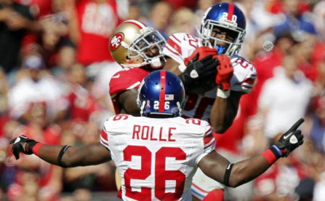 Safety Antrel Rolle of the New York Giants celebrates as cornerback Prince Amukamara intercepts a pass against the San Francisco 49ers in the second quarter at Candlestick Park in San Francisco. Photo: AFP