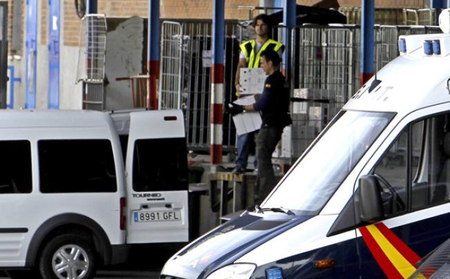 Spanish National Police agents collect documents found after they raided a Chinese business at the Cobo Calleja industrial estate, in Fuenlabrada district, Madrid, on Tuesday. Photo: EPA