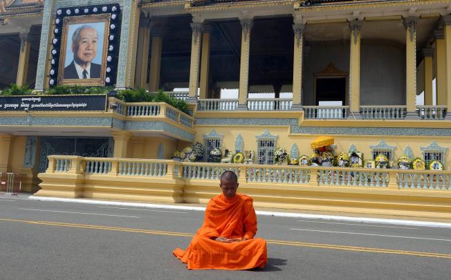 A monk prays as he grieves for Norodom Sihanouk. Photo: AFP