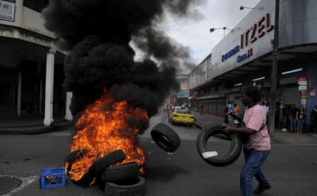  A demonstrator in Panama burns tyres during a protest against a new government law. Photo: Xinhua