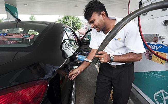 A worker refuels a vehicle in Kuala Lumpur. Canada has blocked Malaysian state oil firm Petronas’ bid for gas producer Progress Energy Resources. Photo: AFP