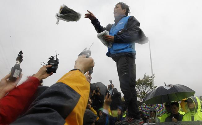 Park Sang-hak, a North Korean living in the South, scatters anti-North leaflets as he speaks at a police roadblock. Photo: Reuters