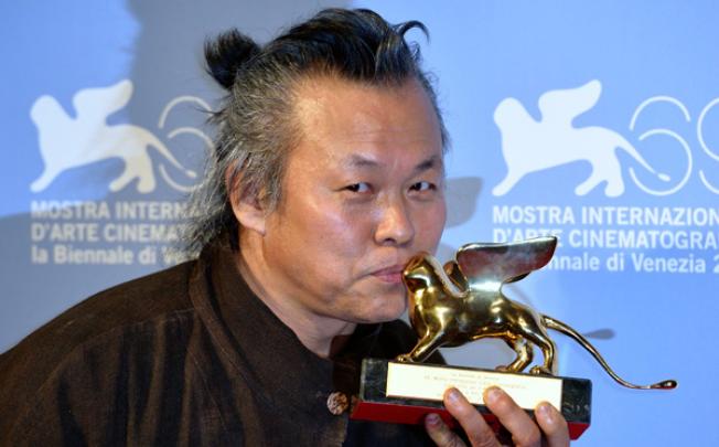 South Korean director Kim Ki-duk kisses the Golden Lion for Best Film for his film <i>Pieta</i> at the Venice International Film Festival on September 8. Photo: Xinhua