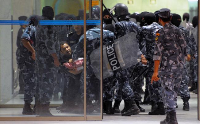 Kuwait riot policemen arrest a man during a demonstration in Kuwait City in the early hours of Monday. Photo: AP