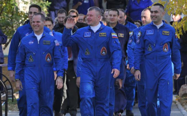 Crew members (left to right) US astronaut Kevin Ford and Russian cosmonauts Oleg Novitskiy and Evgeny Tarelkin walk to a bus during a sending-off ceremony in the Russian-leased Baikonur cosmodrome on Tuesday. Photo: AFP