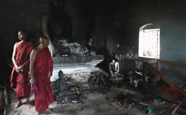 Bangladeshi Buddhist monks look at a Buddhist temple that was torched in Ramu in the coastal district of Cox's Bazaar on October 3. Photo: AP