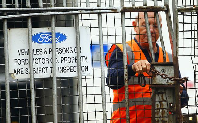 A security guard locks a gate at Ford's Southampton plant. Photo: AP 