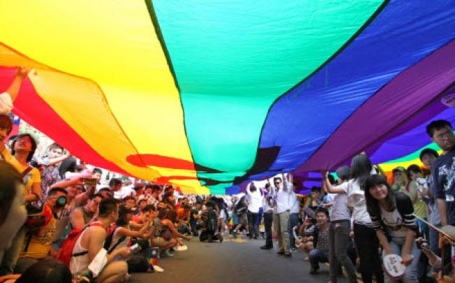 Demonstrators carry a huge rainbow flag as they take part in the 2012 Gay Pride March in Taipei on Saturday. Photo: EPA