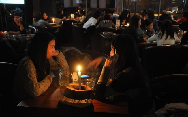 Patrons enjoy a drink and a cigarette in an Ulan Bator bar. From next year, doing so will carry a hefty fine. Photo: Michael Kohn
