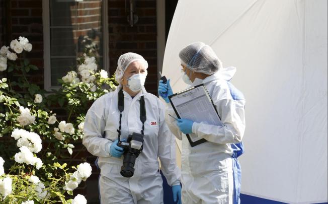 Forensic officers at the UK home of the Alps victims. Photo: AFP