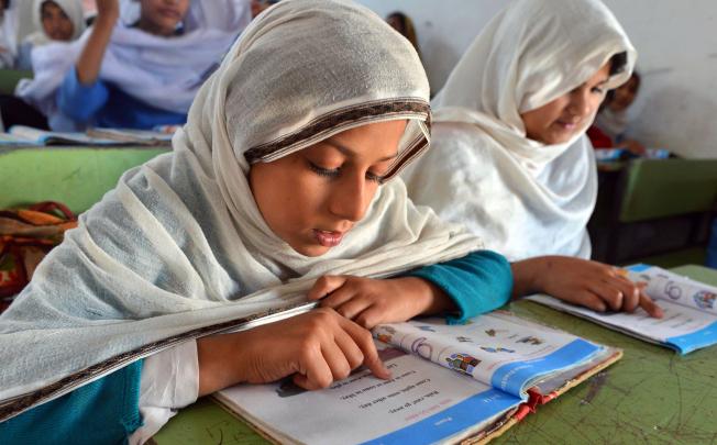 Pakistani girls study at a school in Peshawar, Pakistan. From 1993 to 2010, the number of girls enrolled in primary education increased from 3.7 million to 8.3 million. Photo: AFP