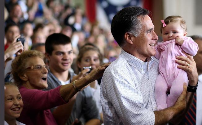 Mitt Romney poses for the obligatory baby photo at a rally in Avon Lake, Ohio, as he steps up his attacks on Barack Obama. Photo: AFP
