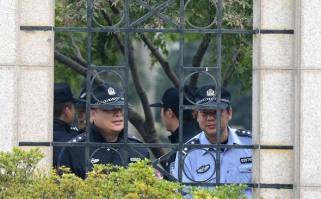 Police look out from the city government offices in Ningbo, in eastern China's Zhejiang province, on Monday after thousands of locals clashed with police during a protest at the construction of a chemical plant. Photo: AFP