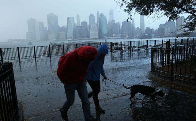 A couple walk in the rain opposite a darkened Manhattan after much of New York lost electricity after Hurricane Sandy struck. Photo: AFP 