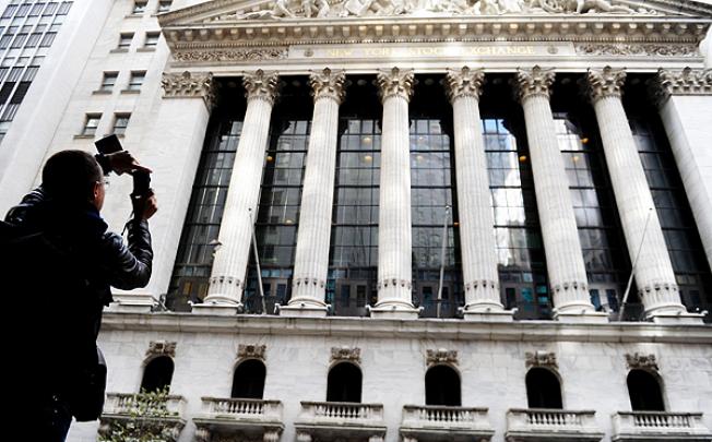 A tourist takes photos of the New York Stock Exchange in Manhattan. Photo: Xinhua