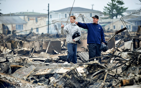 Two men look at the damage left by Sandy in the Queens borough of New York. Photo: AFP