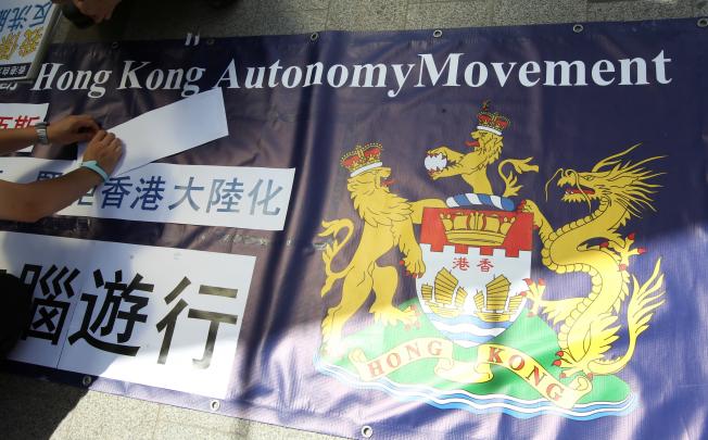 Members of the Hong Kong City-State Autonomy Movement prepare a banner emblazoned with their adopted lion and dragon emblem, before a protest on national education. Photo: SCMP