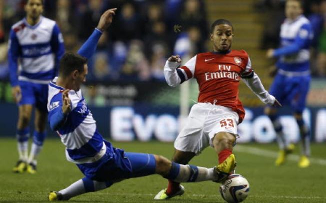 Reading's Sean Morrison, left, vies for the ball with Arsenal's Jernade Meade during the English League Cup soccer match between Reading and Arsenal at Madejski Stadium in Reading. Photo: AP