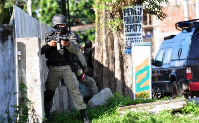 Indonesian anti-terro police, Densus 88, prepare to secure downtown Poso in Central Sulawesi province on Saturday in an effort to raid a terror suspects house. Photo: AFP